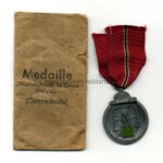 Ostmedaille mit Verleihungstüte, (Hst. 60 - Katz & Deyhle, Pforzheim), Winterschlacht im Osten 1941/42