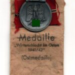Ostmedaille mit Verleihungstüte, Hst. 93 - "Richard Simm & Söhne, Gablonz", Winterschlacht im Osten 1941/42
