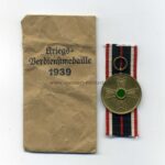 Kriegsverdienstmedaille 1939 mit Tüte, Hst. F. W. Assmann & Söhne, Lüdenscheid