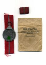 Ostmedaille mit Verleihungstüte, Hst. 23 – “Arbeitsgemeinschaft für Heeresbedarf in der Graveur & Ziselierinnung, Berlin”, Winterschlacht im Osten 1941/42  -Selten!-