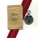 Ostmedaille mit Verleihungstüte, Hst. 18 - "Karl Wurster KG, Markneukirchen", Winterschlacht im Osten 1941/42